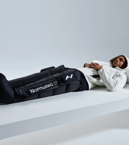 Man lying down wearing Normatec Elite legs